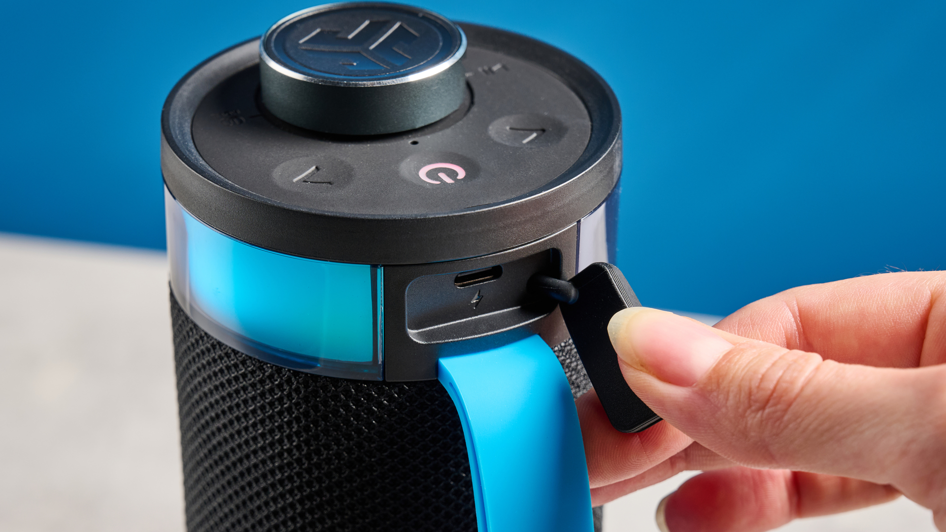 the jlab go party speaker in black with an LED RGB panel and jlab logo photographed in front of a blue background