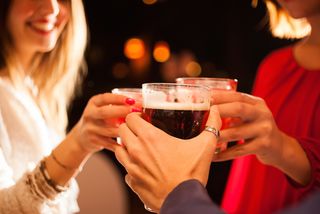 Friends toast with their drinks.