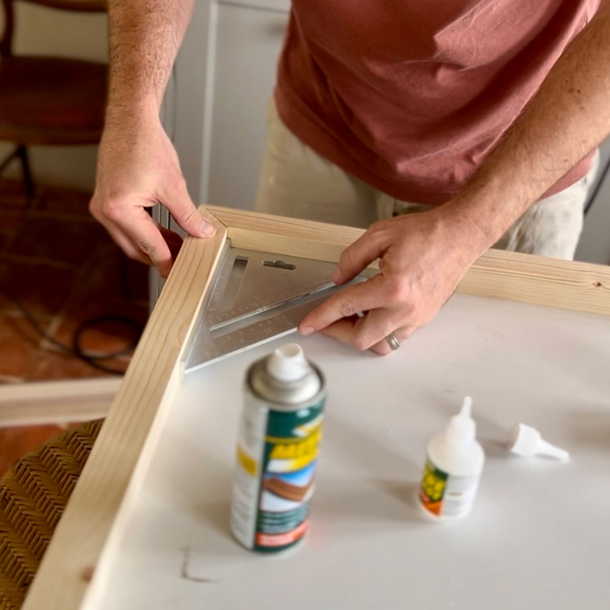 Man using a tool to angle wood frame