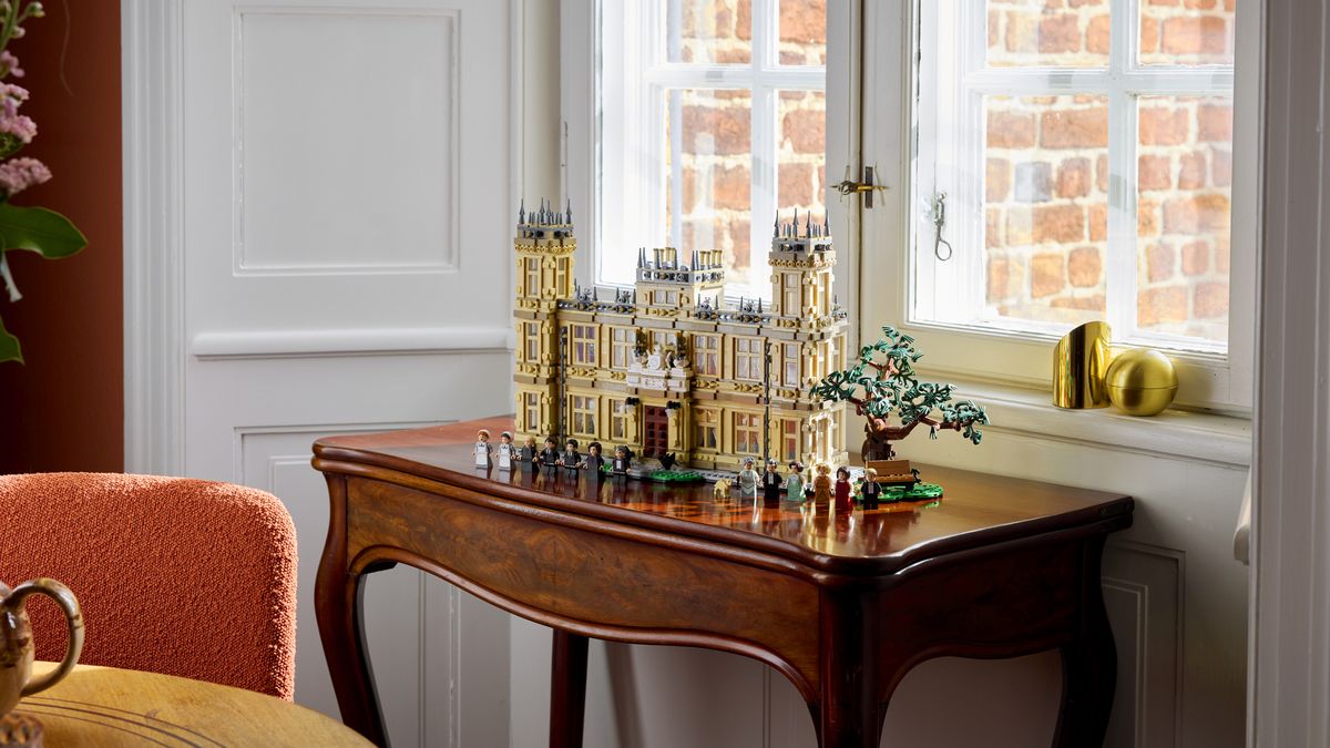 Lego Downtown Abbey and minifigures on a fine, glossy sidetable in front of a window
