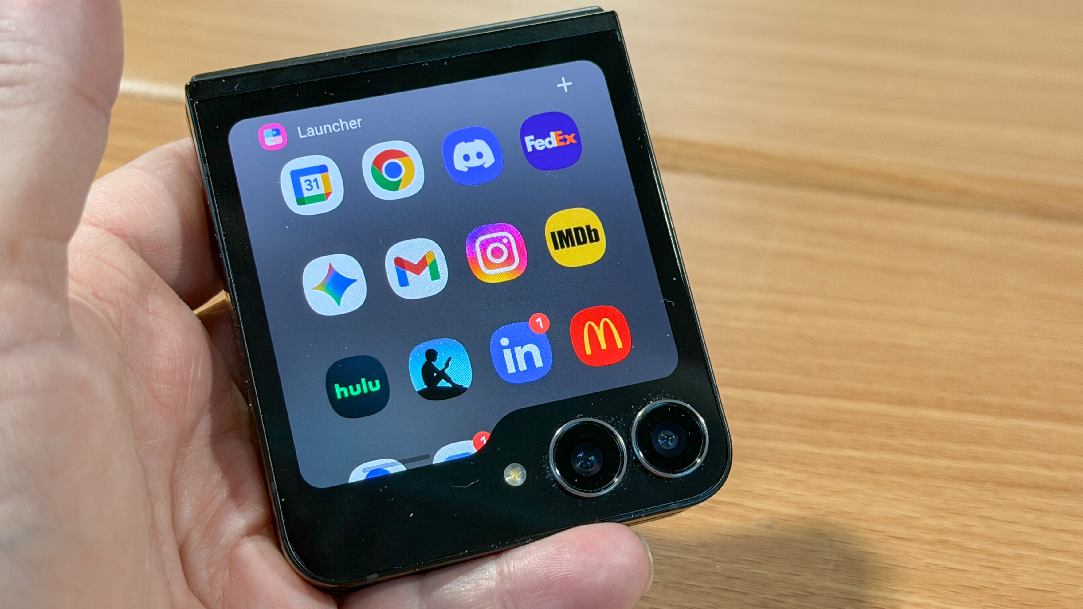 Samsung Galaxy Z Flip 7 FE in piano black color showing content on the cover display and the main screen