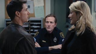 Lee Child as a cop giving Tom Cruise a skeptical look in Jack Reacher