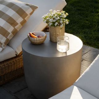 The Caine Outdoor Side Table nestled between two sun loungers