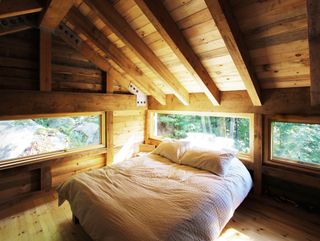 white bed in a log cabin