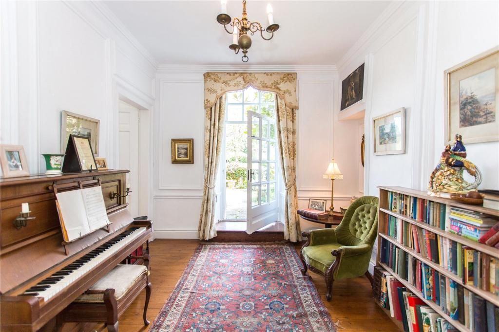 A music room with piano to the left and bookcase to the right