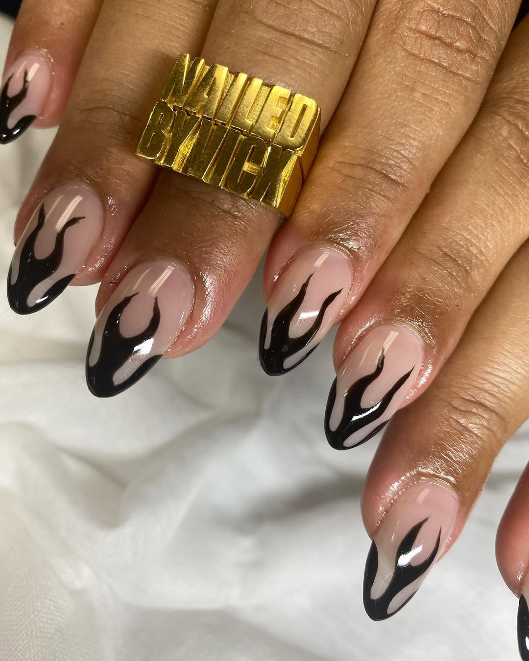 a person wearing a black french manicure with fiery tips