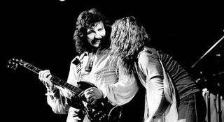 Tonny Iommi smiles as he plays a riff as Black Sabbath Ozzy frontman performs alongside him. The year was 1978, the venue Lewisham, London.