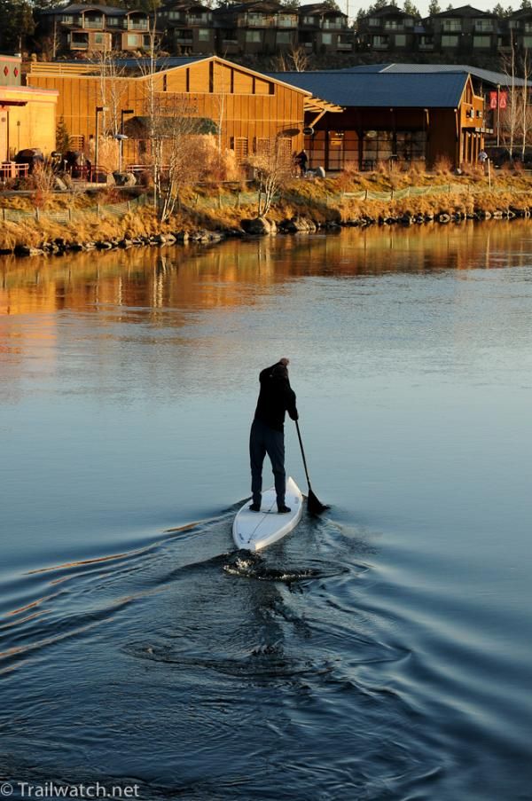 A lone paddler heads up the river next to the race