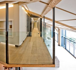 The slender mezzanine houses the wine cellar, a study and a discrete seating area, running around the L-shaped space at the highest point of the vaulted ceiling
