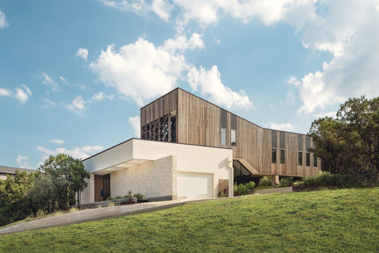 exterior of sustainable home with stone cladding, timber cladding, and lawns