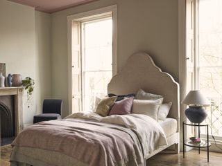 pink and stone bedroom with curvy headboard, side table, shutters, pink ceiling