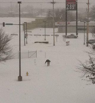 Measuring the historic snowfall in Tulsa, Okla.