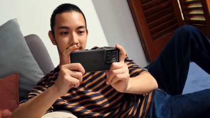 OnePlus 10T being used by a man lying down