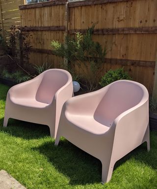 Pink freshly painted IKEA SKARPÖ chairs on grass in yard