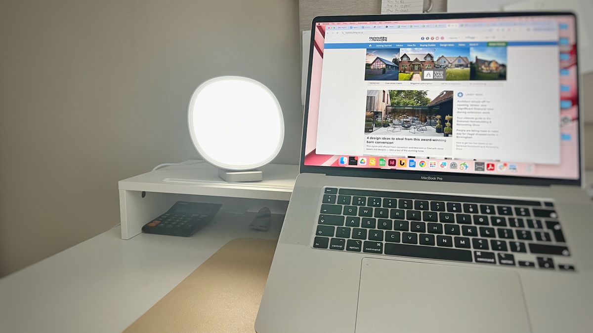 desk with laptop and lumie dash light to side on white riser