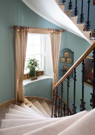 Blue staircase with curtains and windows, artwork