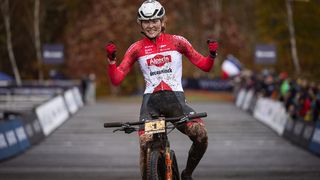 Puck Pieterse crossing the line and celebrating her overall XCO win in 2023