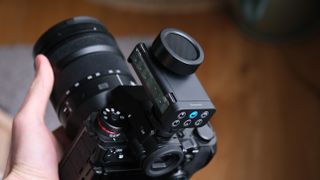 Panasonic Lumix DMW-DMS1 microphone mounted on a Lumix camera body, showing the side control panel and hot-shoe connection.