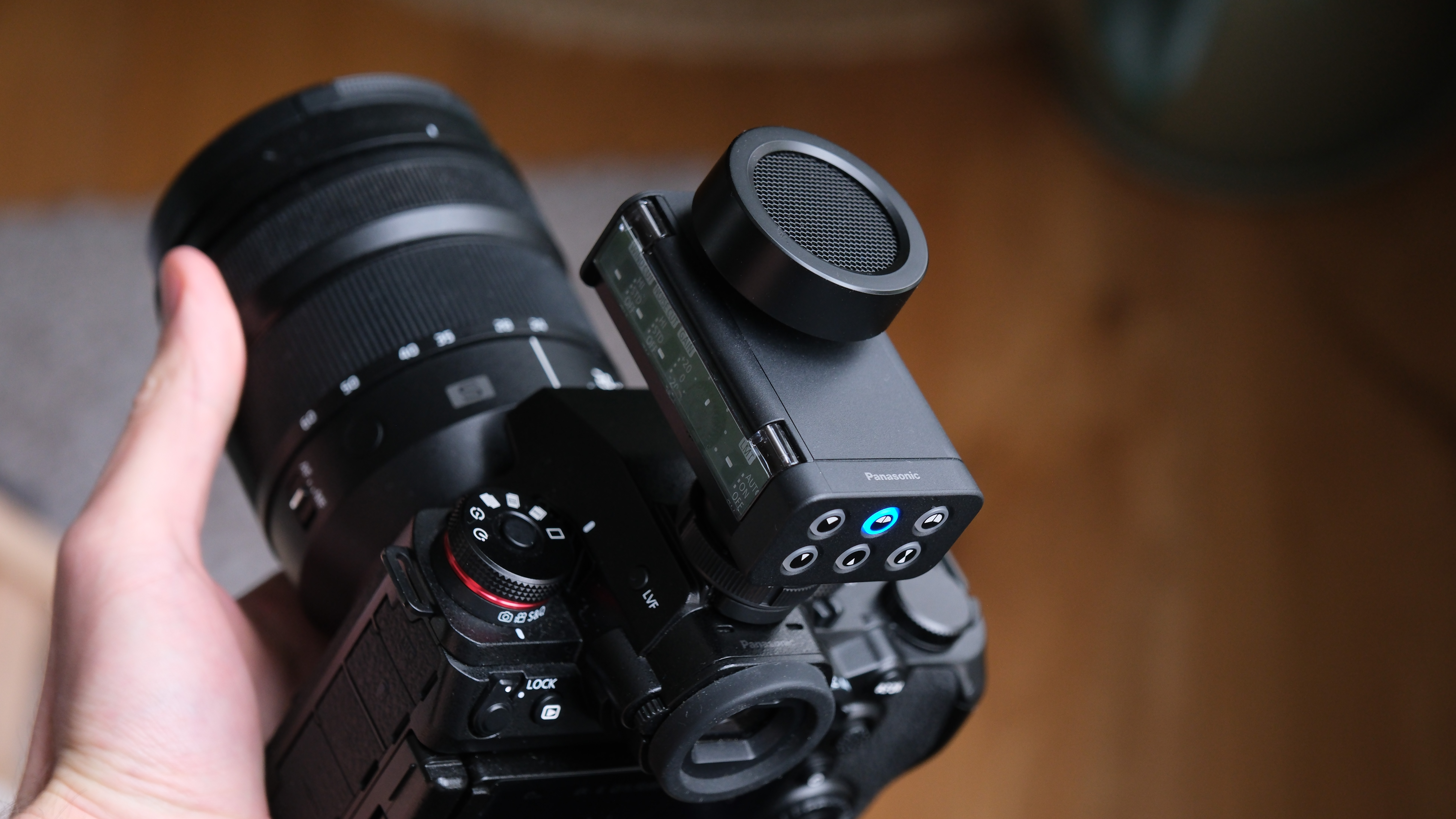 Panasonic Lumix DMW-DMS1 microphone mounted on a Lumix camera body, showing the side control panel and hot-shoe connection.