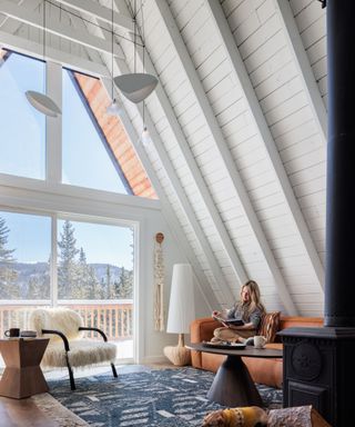 living room with huge triangular picture window and gabled roof painted white