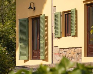 yellow home exterior with green shutters