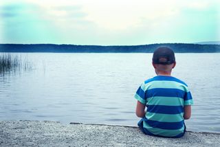 A little boy sits by himself
