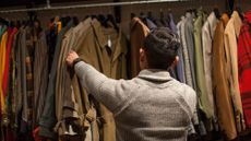 Young man looking through clothes rail in vintage shop
