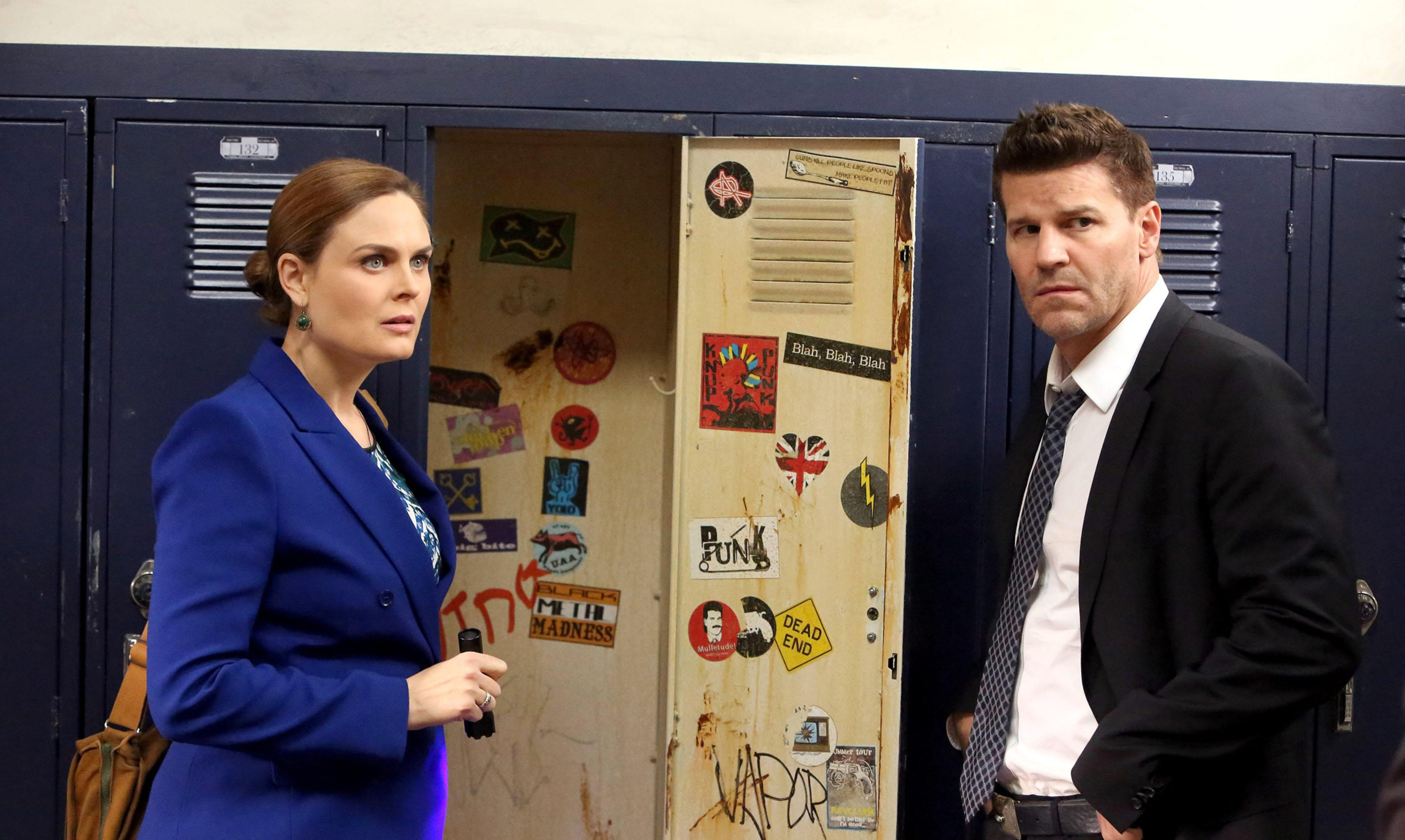 Emily Deschanel and David Boreanaz wear siuts while talking in the police station office room in a still from &#039;Bones&#039;