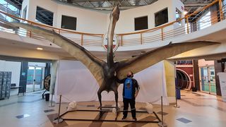 Paleontologist Leonardo D. Ortiz David stands next to a life-size reconstruction of Thanatosdrakon at the Laboratory and Museum of Dinosaurs at the National University of Cuyo in Mendoza, Argentina.