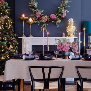 dining table laid out for christmas with foliage and candles