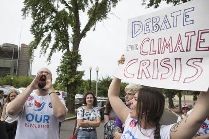 Protestors urge the DNC to hold a climate change debate.