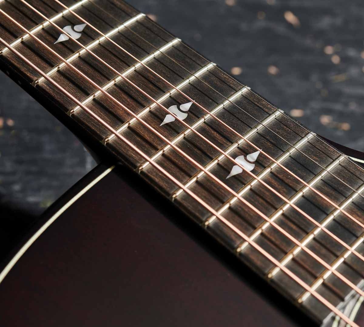 Again, we have some ebony on a fingerboard inlayed with acrylic faux pearl.