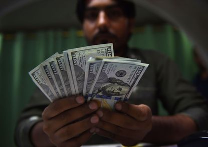 A Pakistani currency dealer counts U.S. dollars.