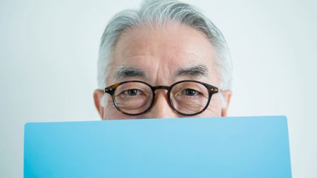 Man hiding his face with blue file