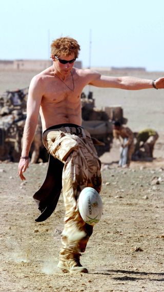 Prince Harry kicking a rugby ball while in the army