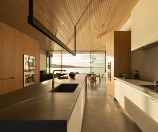 modern wooden kitchen with concrete floor and sea views