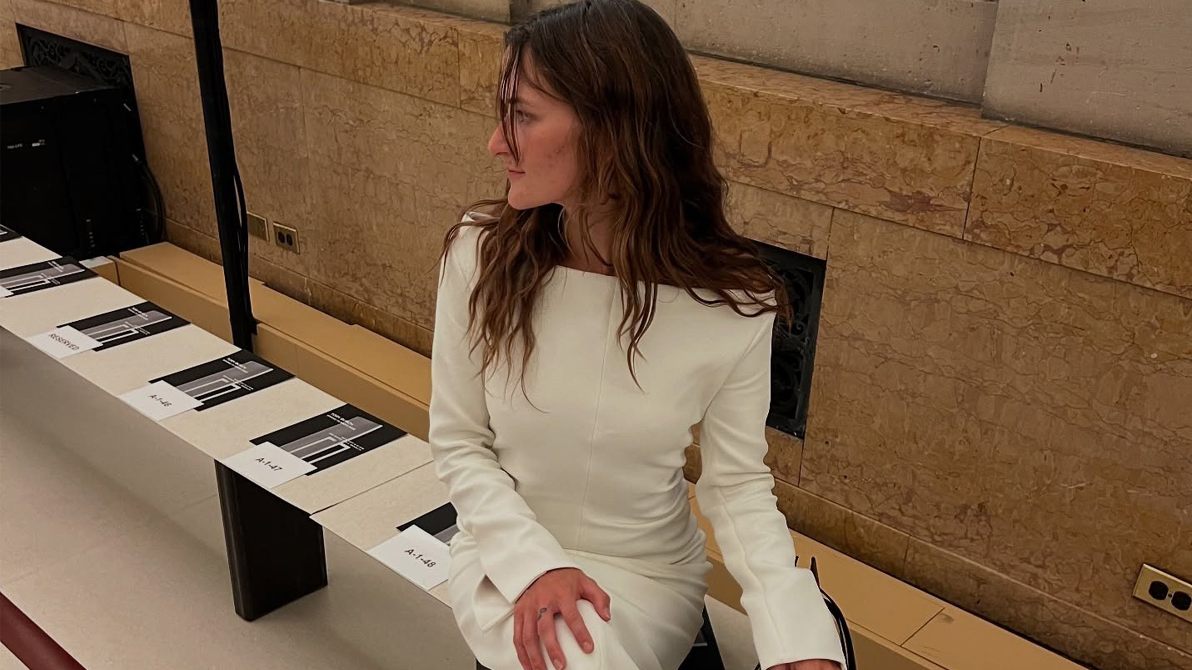 Eliza Huber wearing a white dress with black boots at the Tory Burch show in New York.