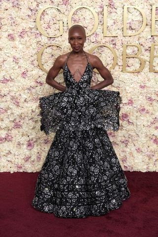 A photo of Cynthia Erivo showing off her plunging black peplum gown at the 2025 Golden Globes.