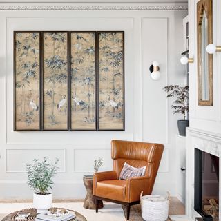 A white room with a brown leather chair and decorative panels