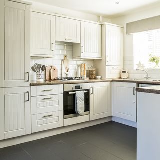 kitchen with white tiles and cabinet