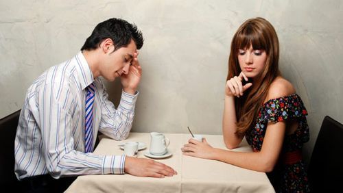 Couple sat at table ignoring each other