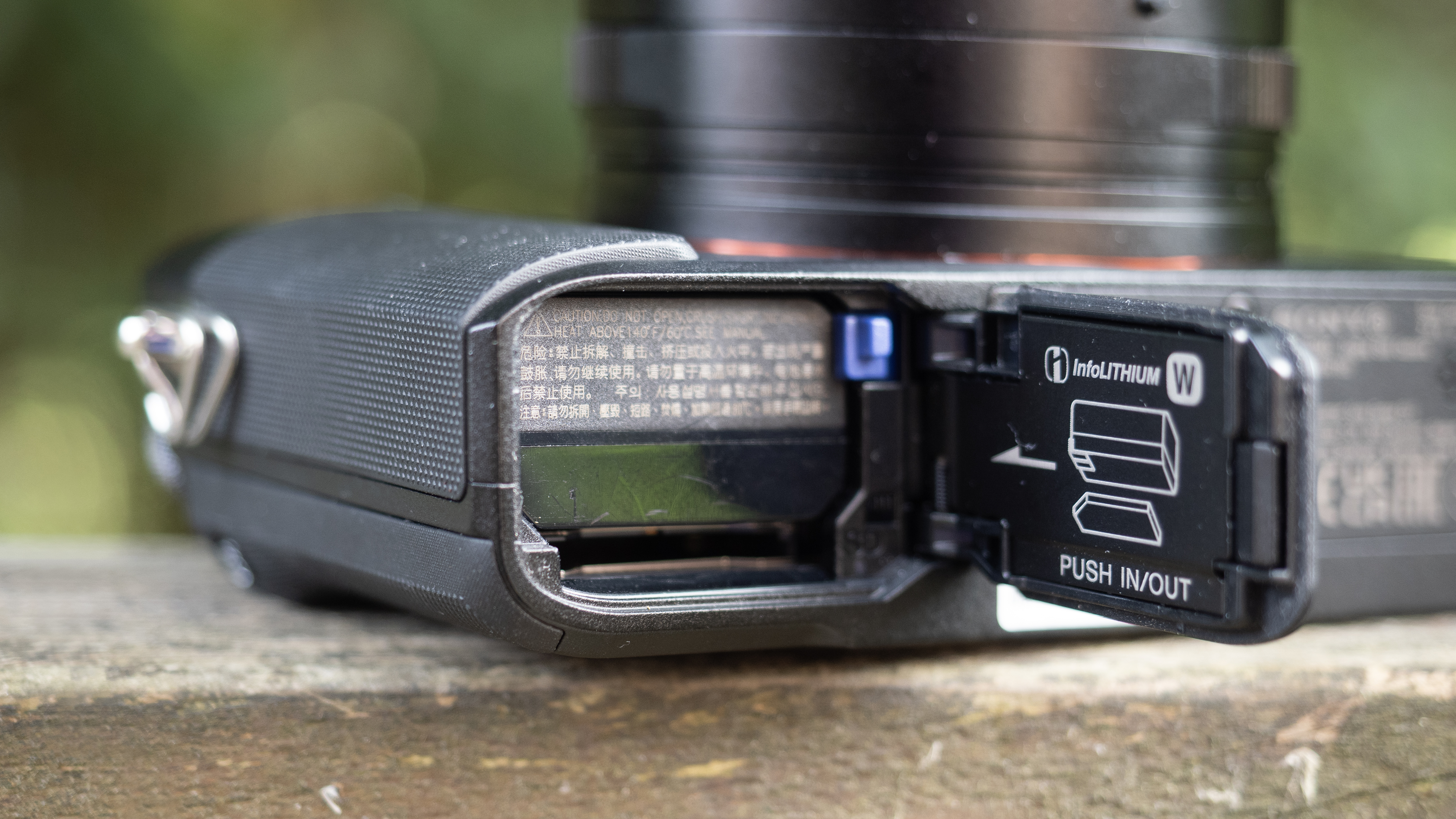 Sony RX1R III on a wooden surface in a woodland environment