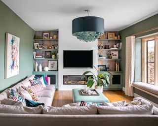 Green living room with l-shaped sofa and wall-mounted tv