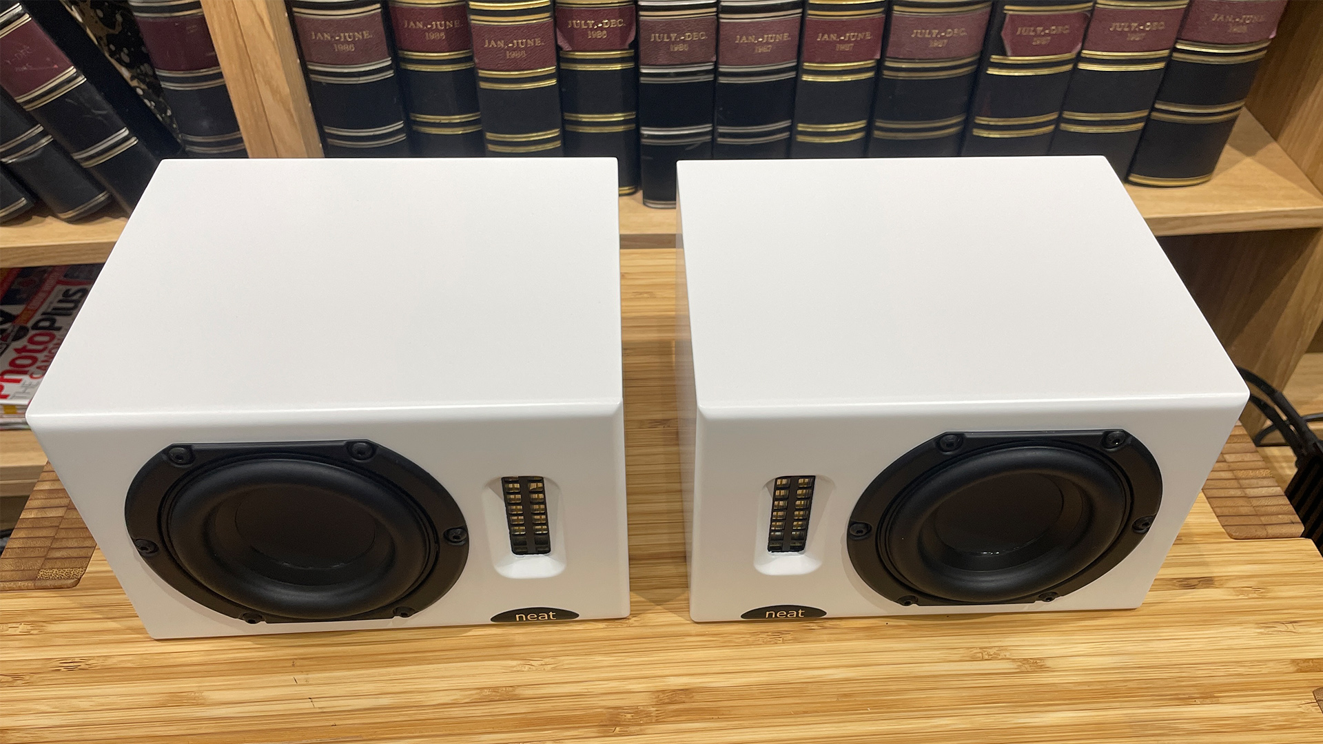 Neat Iota II speakers in white finish placed on wooden shelf
