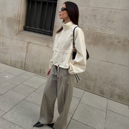 Johanna wears a windbreaker and trousers.