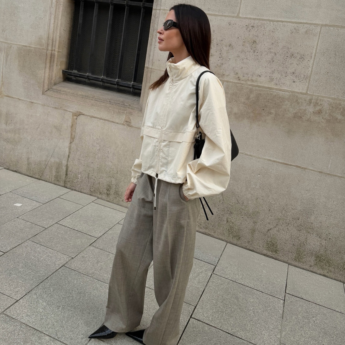 Johanna wears a windbreaker and trousers.