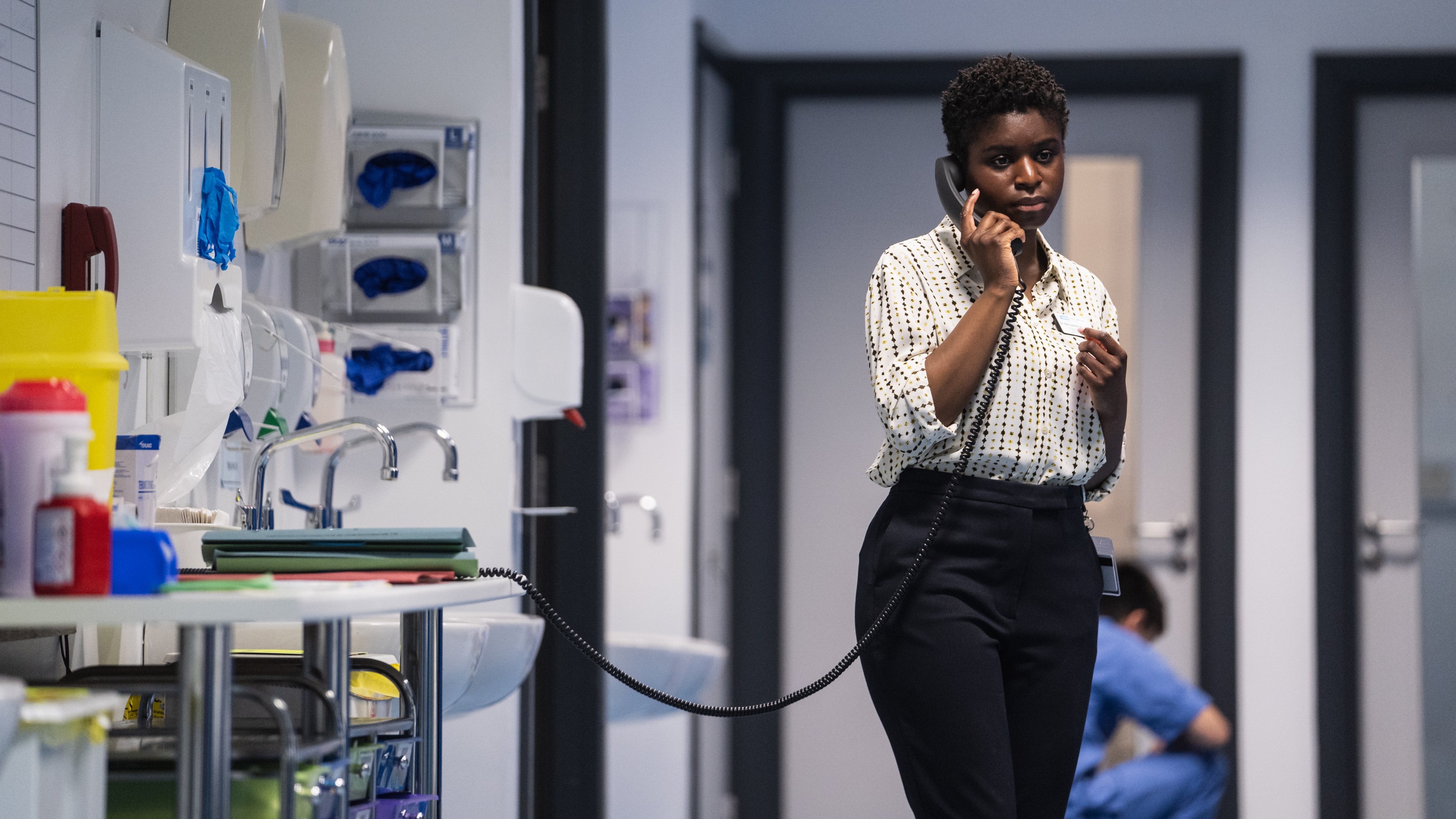 Pictured: JESSICA LAYDE as Bernadette on the phone on a hospital ward