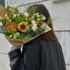 A woman carrying a colourful bouquet of flowers