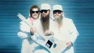 ZZ Top dressed in white fur coats holding a white guitar