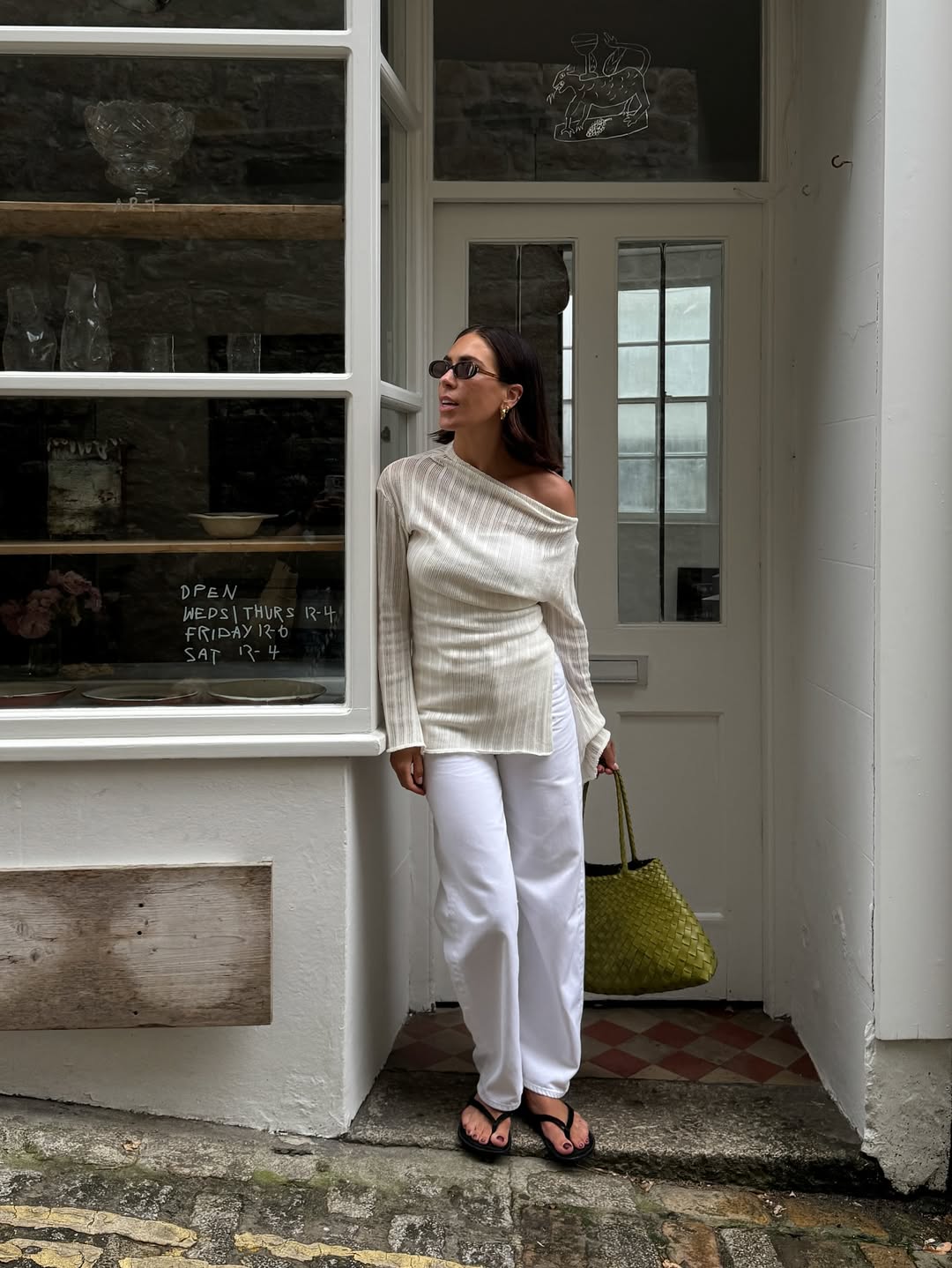 Jessica in a sheer jumper and with a green handbag